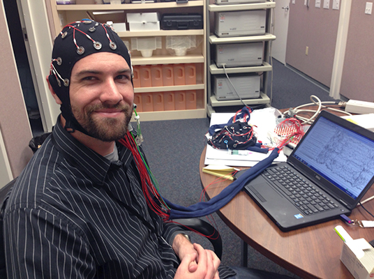 Image of a research subject wearing and configuring an EEG.